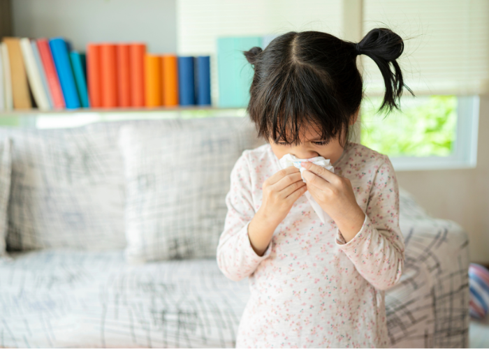 Ein Kind, das sich die Nase schnäuzt wegen seiner Allergie.