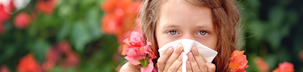 Kind mit Allergien putzt sich die Nase.