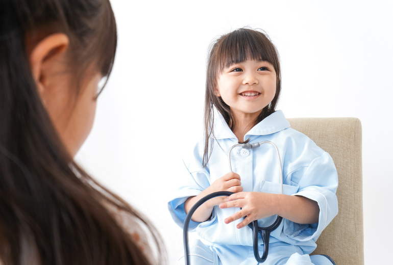 Kind in einem Arztkittel.