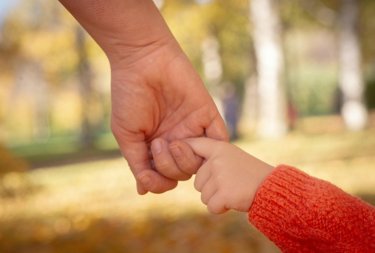 Kind hält Händchen.