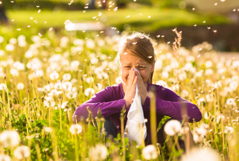 Kind hat Allergien, während sie im Gras sitzt.