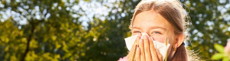 Ein Mädchen schnäuzt sich die Nase