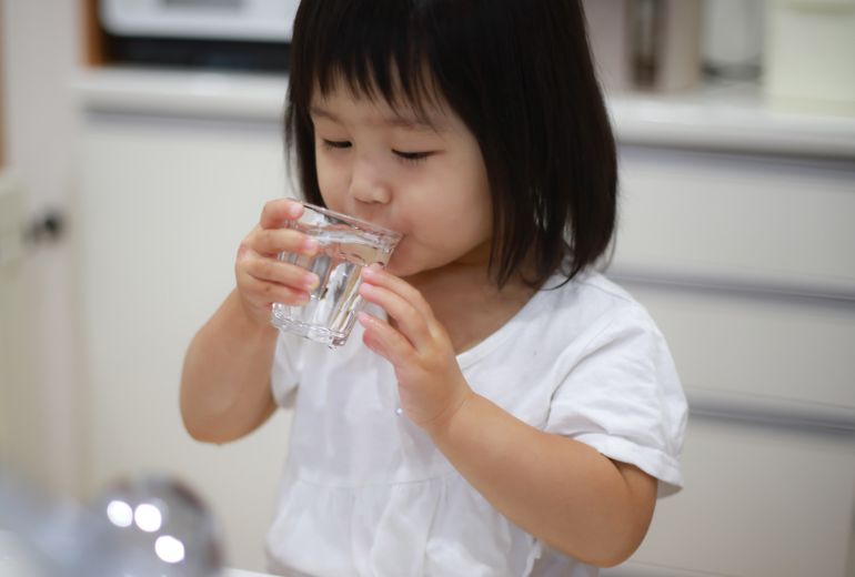 Kind trinkt ein Glas Wasser für den H2-Atemtest.